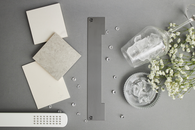 Maskownica grafitowego szczotkowanego odpływu ściennego w aranżacji z pasującymi akcesoriami wyposażenia wnętrz