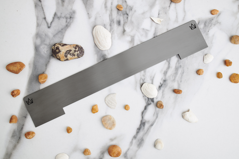 Maskownica dekoracyjna szczotkowanego grafitowego odpływu ściennego na tle jasnej płytki