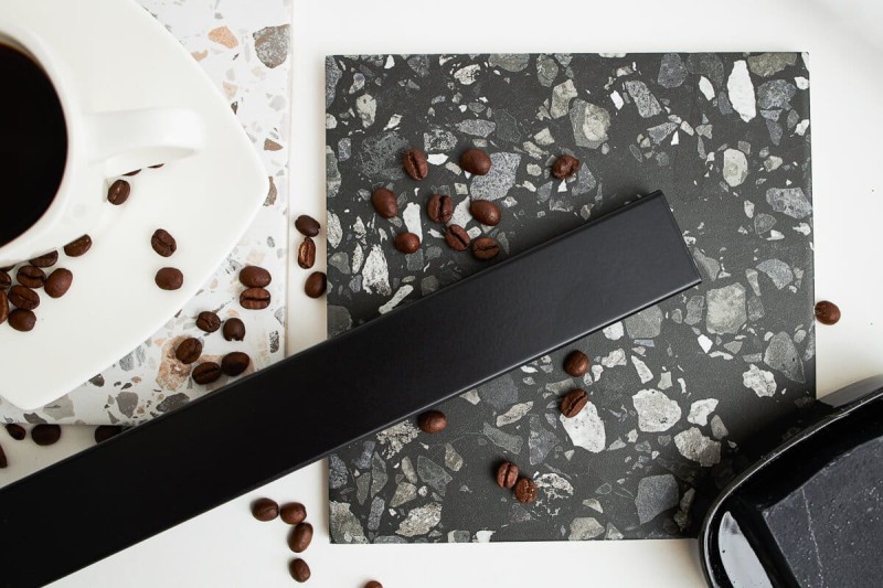 Odpływ przyścienny czarny w aranżacji z płytkami łazienkowymi.