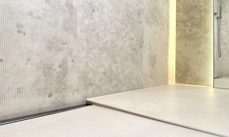 Grafitowy odpływ przyścienny zamontowany w łazience.