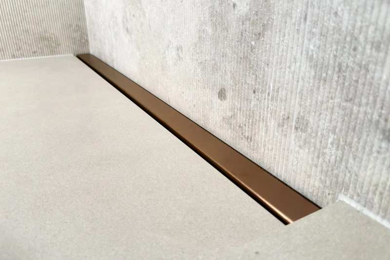 Odpływ liniowy przyścienny na pełną szerokość prysznica - różowe złoto szczotkowane