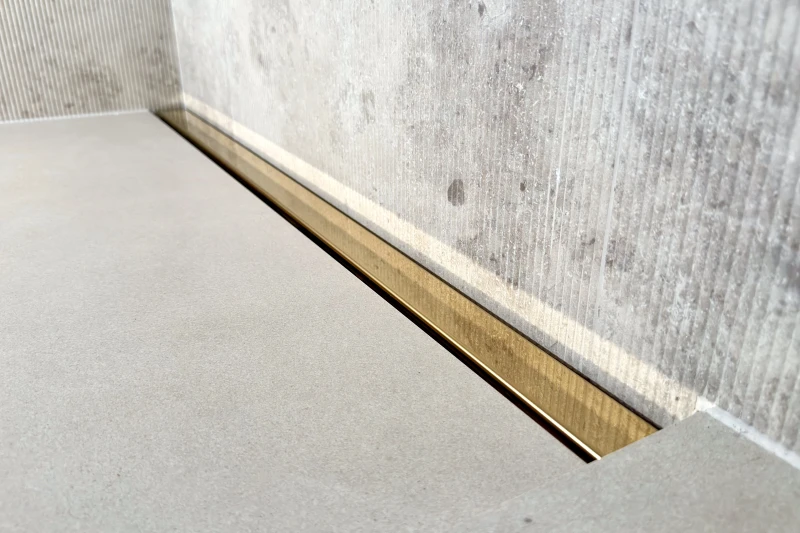 Odpływ liniowy przyścienny złoty na pełną szerokość prysznica