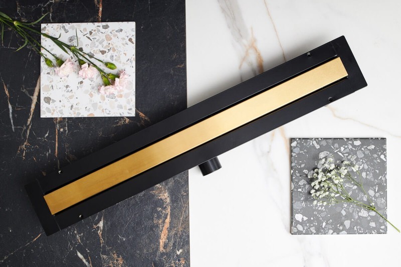 Super niski odpływ liniowy LINE PRO w kolorze szczotkowanego naturalnego złota na tle białej i ciemnej płytki