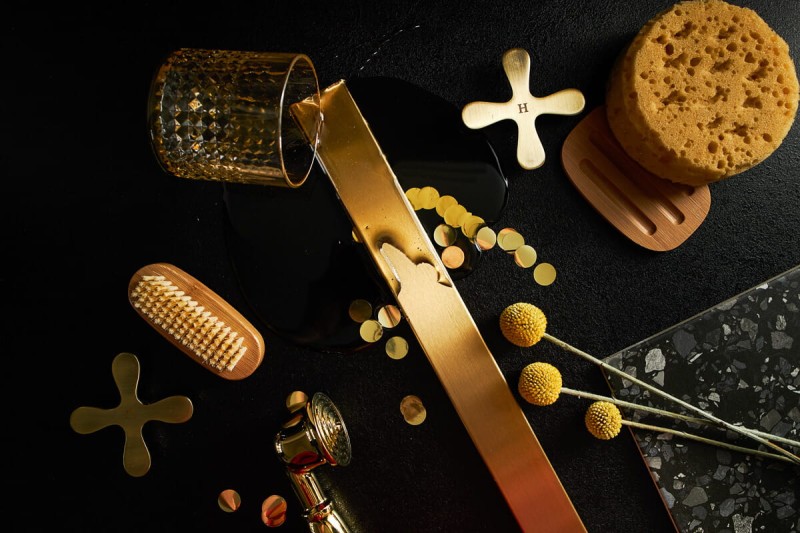 Szczotkowany złoty odpływ liniowy w aranżacji z innymi złotymi elementami wyposażenia łazienki