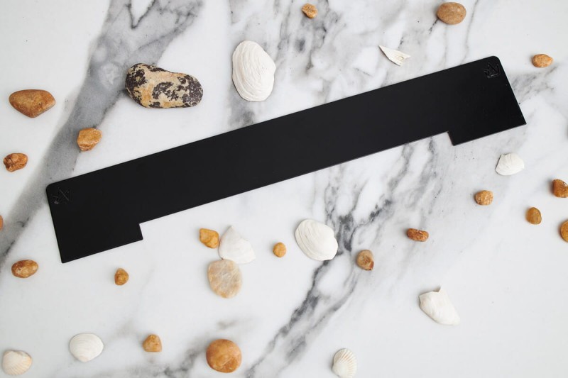 Maskownica dekoracyjna czarnego odpływu ściennego WALL PRO Soft Black na tle jasnej płytki